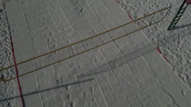 Beyaz kum plajı voleybol sahası. Ağlarla çevrili beyaz kumullar. Oyun alanının çizgileri mavi tekstil plastik kayışlardan yapılmıştır