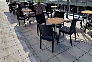 Şirket kafesi ve çalışanlar yararına. Terasta, şemsiyelerin altında, elinde kahveyle klimalı bilgisayar salonundaki işyerinden çok az mesafede oturuyor.