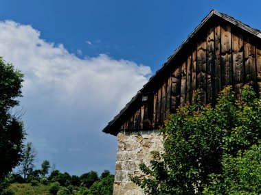  Çalıların arasında fazla büyümüş ahşap bir çadır var. Yazın romantik bulutlar. Eski bir mülk satın almak ve internet olmadan eski zamanların güzelliğini tecrübe etmek.