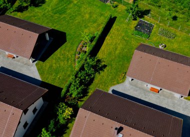 Güzel bir bahçedeki terasta tel metal sandalyeler ve oval masa gibi bahçe mobilyaları var. gri beton teras. Çimen / çiçeklendiren, süsleyen otlar,