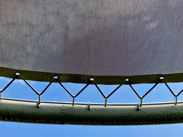 stock image tying canvas stretched, shading from the sun and rain over the terrace of the restaurant, on the playground in the kindergarten, on promenade. pergola with pipe, tube gray beams, on white metal steel