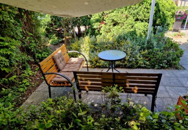 yellow canvas stretched, shading from the sun and rain over the terrace of the restaurant, on the playground in the kindergarten, on promenade. pergola with wooden bench, on white metal steel clipart