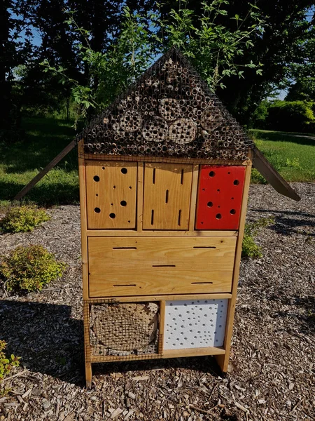 houses for insects, hotels for solitary bees, beetles attracting  and butterflies for moths and butterflies. in a city park on a housing estate in the winter stands in the snow, road barrier