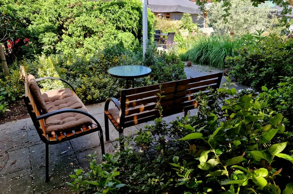 stock image yellow canvas stretched, shading from the sun and rain over the terrace of the restaurant, on the playground in the kindergarten, on promenade. pergola with wooden bench, on white metal steel