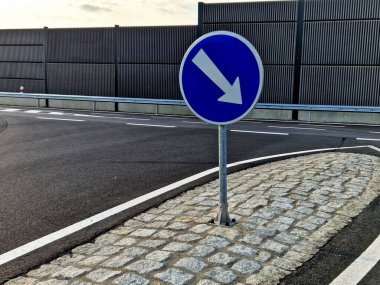 Merkeze yakın yuvarlanmış bir pervazda gri granit küplerin kaldırımları. eğimli beton kaldırımlar, bir ulaşım merkezi, çemberin ortasında çiçekler ve otlar var. çok yıllık çiçek tarhı 