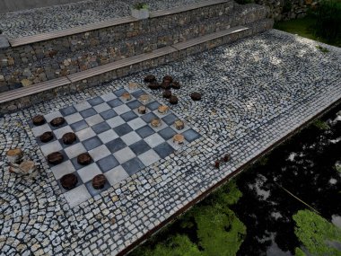 Rıhtımdaki parkta dinlenme terası. dama tahtası desenindeki kiremitler ve bloklar dama taşlarını temsil ediyor. Taslak masa oyunu. Büyük ölçekli. granit döşeme.