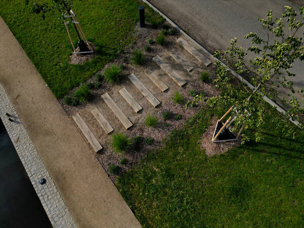 Steps from the beams on the terrace by the shore. lined with decorative beds and avenues of linden trees. park improvements near the water surface, a bike path and mooring posts for fishermen's boat