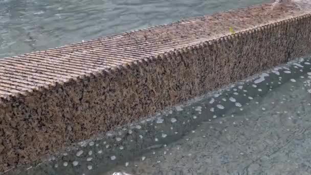 正方形花岗岩铺筑在人行道上的一条狭长地带 水喷出交替喷出的高度 水的特征直接从公园里的鹅卵石正方形中产生 湿地砖木板路 — 图库视频影像