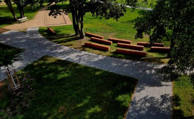 Seyirciler için tiyatro amfi tiyatrosu. Tahta prizmalar beton temelde. Tek bir tahta parçasından yapılmış ayak kesimi kahverengi, ptanque oyun alanı, bowling, harman