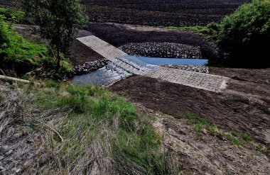 Toprak yol nehri geçen bir dereye çıkıyor ve sel yolu geçilemez olduğunda da devam ediyor. Su kaynaklarının yenilenmesi ve arazilerin dolambaçlı yoldan boşaltılması. 
