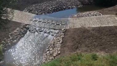 Toprak yol nehri geçen bir dereye çıkıyor ve sel yolu geçilemez olduğunda da devam ediyor. Su kaynaklarının yenilenmesi ve arazilerin dolambaçlı yoldan boşaltılması. 