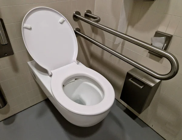 供轮椅使用者使用的厕所 带有杠杆的倾斜的镜子 以及马桶的辅助靠背 陶瓷水槽稍微低一点 镰状高度可调给坐着的人 — 图库照片