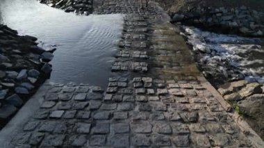 Toprak yol nehri geçen bir dereye çıkıyor ve sel yolu geçilemez olduğunda da devam ediyor. Su kaynaklarının yenilenmesi ve arazilerin dolambaçlı yoldan boşaltılması. 