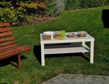 Çocuklar şefçilik oynadılar. Bilinmeyen malzemelerle dolu kirli kaplar. Masanın üzerinde kum ve çiçekler var. Doğada bulunan artıklardan ve malzemelerden yemek pişirme fantezisi.