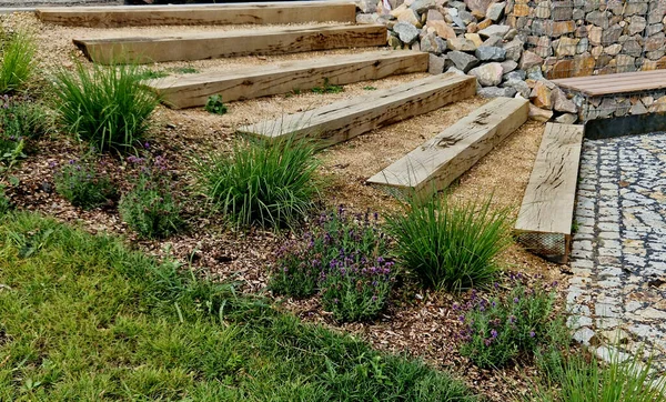 stock image steps from the beams on the terrace by the shore. lined with decorative beds and avenues of linden trees. park improvements near the water surface, a bike path and mooring posts for fishermen's boat