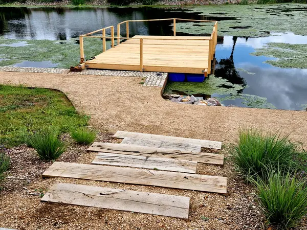 公园游客的码头 两步就到了 木板平台在水面上 有船坞的池塘 矩形的平面图 平台上没有栏杆 — 图库照片