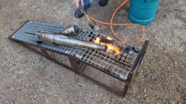 Yanan motorsiklet egzozu Benzin depozitolarını ve depozitolarını temizlemek. Gaz ocağıyla karbon ve kurumu tutuştur. Egzoz gazı susturucu borusu, oto tamircisi.