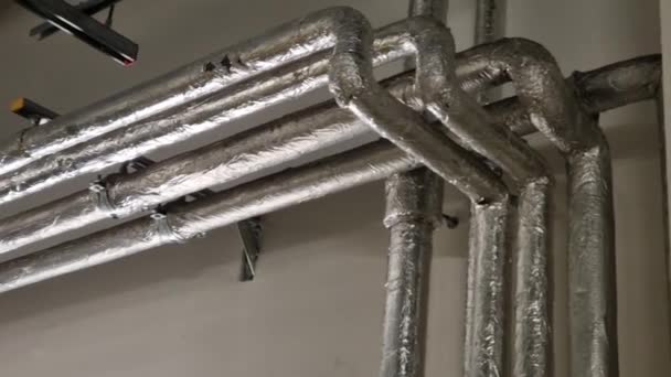 産業ビルの操作の管のためのホイルか熱損失に対して絶縁される複数の熱湯の配分システムが付いているアパートの建物 私達の配管工は彼の道を知っています — ストック動画