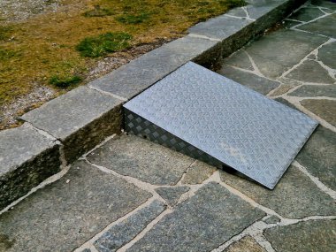 Paslanmaz çelik kama, restorana içecek ve yiyecek sağlayan iki tekerlekli arabalarla duvarı aşmak için kullanılıyor. desenli metal levha