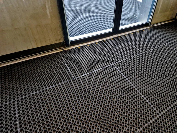 rubber mat used to protect paving in winter when everything is slippery and wet. entrance area at the automatic sliding doors of the wholesale shop. cable car, ski lift pays attention to safety