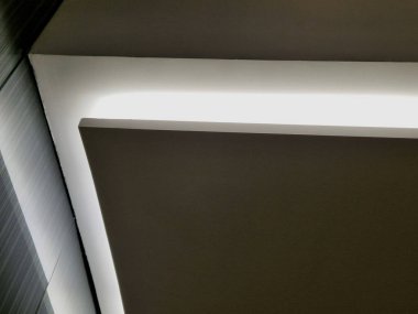 Kemerdeki LED şeritlerle aydınlatılmış bir korniş. Kahverengi ahşap kontrplakla kaplı duvarlar. Işık konileri neşeli bir izlenim bırakır. Büyük bir ünü ve atmosferi olan bir gece kulübü.