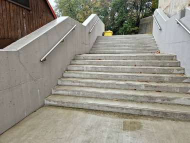 Kamu binasında beton kenarlı bir merdiven. Güvenli merdivenin iki tırabzanı var. Birinin 12 yaşın altındaki çocuklar için boyu kısaltılmış. Okulun girişinde tuğla, siyah, kırmızı. Sahtecilik