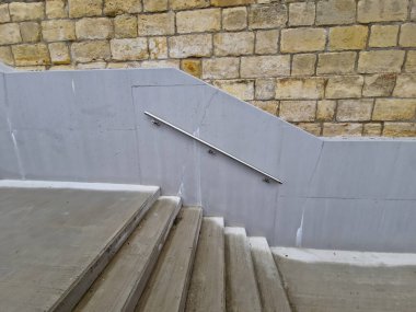 Kamu binasında beton kenarlı bir merdiven. Güvenli merdivenin iki tırabzanı var. Birinin 12 yaşın altındaki çocuklar için boyu kısaltılmış. Okulun girişinde tuğla, siyah, kırmızı. Sahtecilik