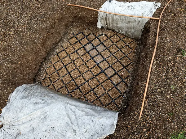 expanded clay on the roof garden is a component of substrate. probe in the ground shows nop film with water retention capacity in square moldings made of hard black plastic, digging, excavation, probe