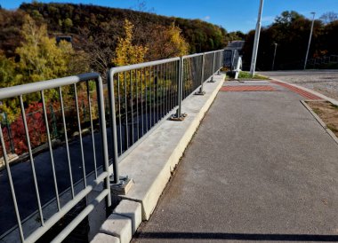 Yolun kenarında beton bir duvarla güçlendirilmiş yol bariyerleri ve mavi parmaklıklar var. Otobanın yüzeyinden süzülen yağmur suları için oluklar. güçlendirilmiş beton