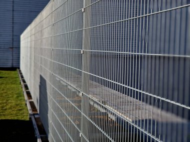 Güçlü galvanize kaynaklı tel örgüler endüstriyel salonlar, lojistik merkezleri ve havaalanları etrafında kullanılır. Kapı kolu ve kilidi olan kapı. Dayanıklı ve ucuz parçalar her yerde çabucak yapılabilir.