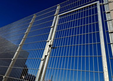 Güçlü galvanize kaynaklı tel örgüler endüstriyel salonlar, lojistik merkezleri ve havaalanları etrafında kullanılır. Kapı kolu ve kilidi olan kapı. Dayanıklı ve ucuz parçalar her yerde çabucak yapılabilir.