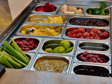 çeşitli meyveler paslanmaz çelik dondurma kaselerinde. Meyve suyu kokteyli olarak karıştırılmış olabilir. Müşteri kivi, portakal, ahududu ve kereviz, ananas ve çilek seçebilir.