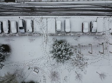 Parktaki çit, bir peyzaj mimarı tarafından kahverengi ahşaptan yapılmış yeni bir pergola. Hornbeam çitleriyle kaplı. Banklar sarmaşıkların altında, hepsi kar, çöp tenekesi, sokak, çöp, kaplanmış