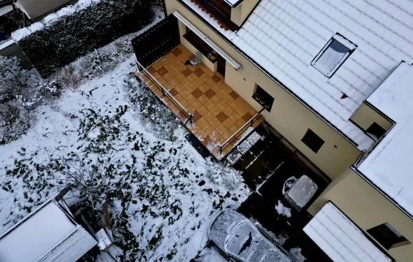 snowy yard with terrace. the parked car is subtly camouflaged in outline. observation of the object by the enemy with the help of the drone operator. cleaning and maintenance of advertising objects