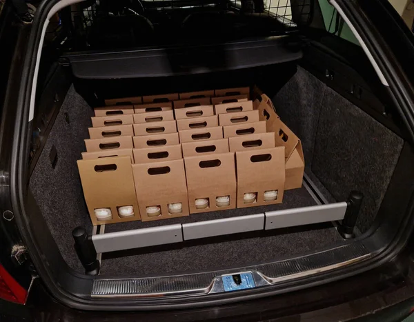 business manager\'s car storage space. car trunk full of gifts from clients and business partners. employees delivering carton boxes with wine and snacks.