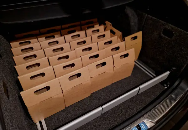 business manager\'s car storage space. car trunk full of gifts from clients and business partners. employees delivering carton boxes with wine and snacks.