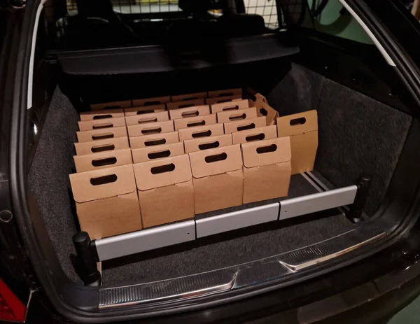 business manager's car storage space. car trunk full of gifts from clients and business partners. employees delivering carton boxes with wine and snacks.