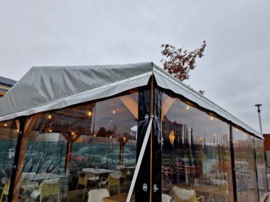 Yazın çok işlek restoranların ön bahçeleri kışın boşaltılır. Çözüm, şeffaf bir terzi yapımı folyoyla pergola kaplamak. Gaz ocağıyla ısıtılabilir. köşe, yükle