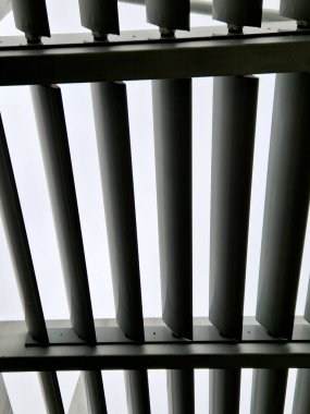 Otobüs durağının metal inşaatı, çardak pergola barınağı. Çatı ve duvarlar tırmanma tesisleri için bir halat ağıyla örülmüş. Paslanmaz çelik eşleşmelerle sabitlenmiş. siyah blok şekilli tünel,