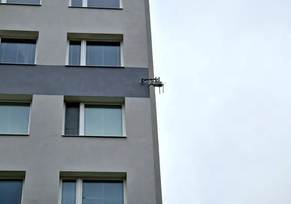 a wireless internet transmitter and amplifier is installed high on the facade of the apartment building.