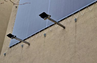 advertising tarpaulin installed by cable into the metal galvanized eye on the facade of the house. Mobile advertising solutions, easily replaceable content for outdoor use on apartment buildings