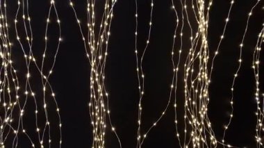 Koyu mavi arka plandaki ışık zincirleri gece yıldızlı bir gökyüzünü andırıyor. Noel için aydınlatılmış süslemelerle sergi standı, dal, daire, huş ağacı kabuğu, beyaz, 