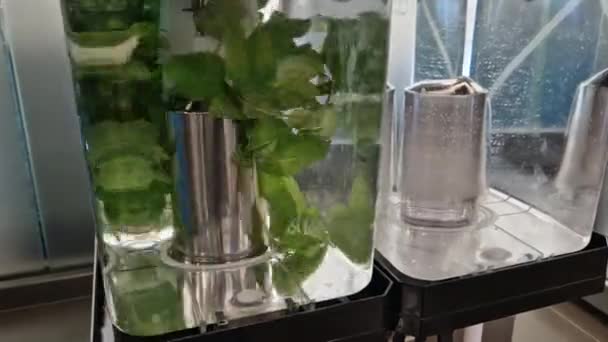 这种饮料机通过搅拌螺旋桨把果汁 水和香草混合在一起 清凉的饮料 以保持口感和新鲜 2个透明的容器 学校餐厅有水龙头 — 图库视频影像