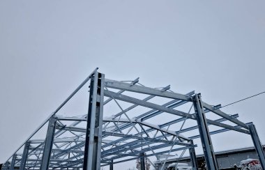 Building construction from metal trusses. lattice structure of the frame of an industrial building. A large thick tangle on the ceiling of a building under construction. shiny metal profiles steel