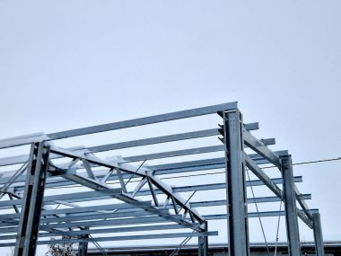 Building construction from metal trusses. lattice structure of the frame of an industrial building. A large thick tangle on the ceiling of a building under construction. shiny metal profiles steel