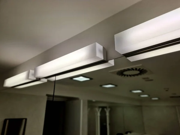 the beauty and hairdressing salon has lights above the mirrors. ceiling equipped with grid ventilation.