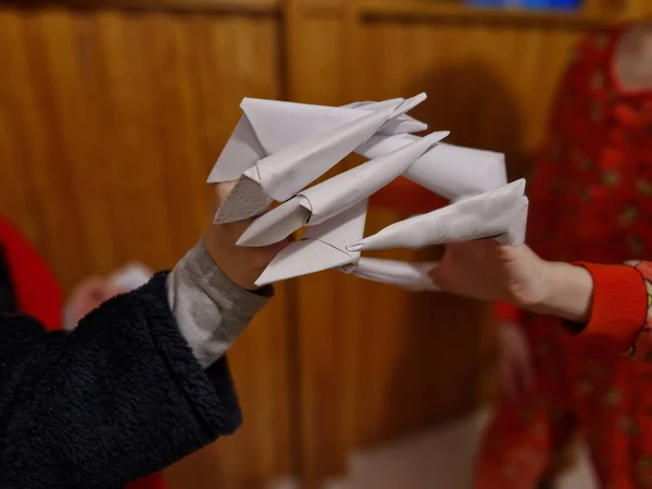 the children made their fingers out of paper. claws from a folded sheet of white paper form monstrous tiger paws. school kids are scared of it and fight with each other