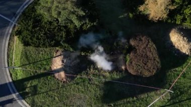 Sıcak suyla boruları tamir etmek ya da sisli ya da tozlu bir madeni andıran derin zırhlı bir çukurda buhar çıkarmak. Girişe karşı korunmak için geçici bina çiti ile sınırlandırılmış. 