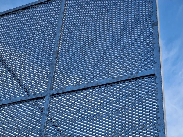 construction of a brick fence to prevent thieves from climbing into the garden. perforated metal sheet fence in the shape of squares with bracing against the wind, design, modern, windbreaker