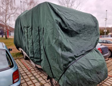 Karavan çekici aracının arkasında bir tekerlek çubuğu ile donatılmış. Otoparkta bir karavanda gezginler yaşıyor. Kedi, köpek gibi tabureye bakar, kamuflaj yapar.